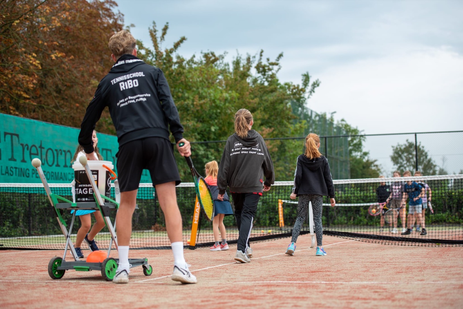 Kinderen en trainer tijdens een clinic op een gravelbaan